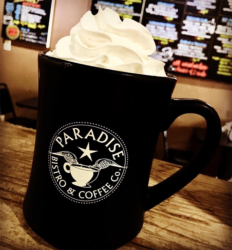 Coffee cup with logo topped with whipped cream